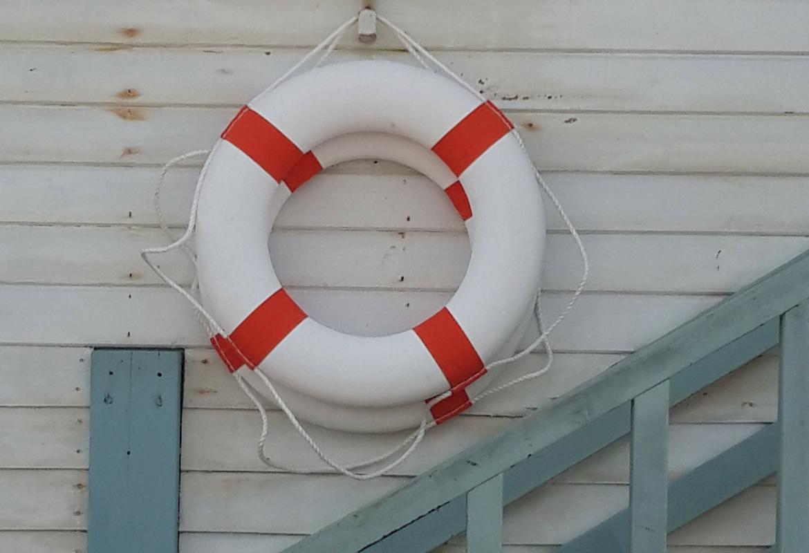 Dos salvavidas colgados en una pared blanca
