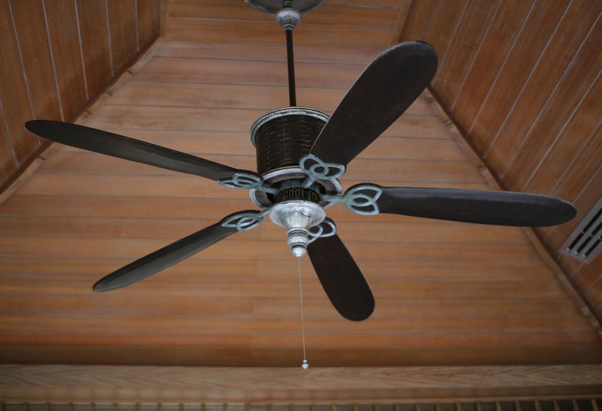 Imagen de un ventilador de techo de madera visto desde abajo