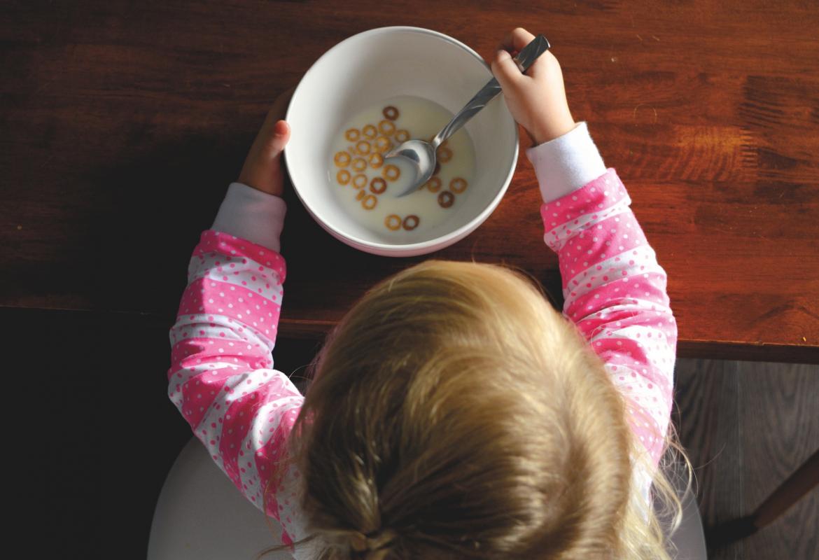 Niña comiendo un bol con leche y cereales