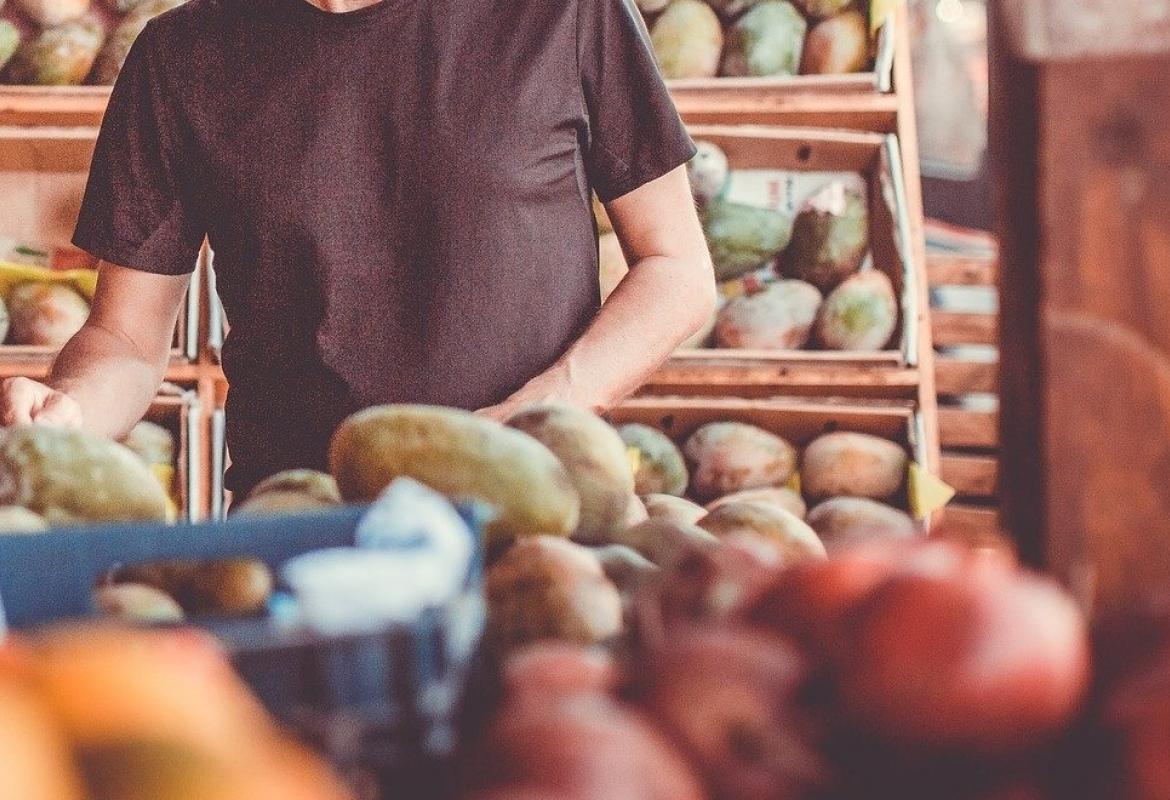 un hombre coge frutas en una tienda