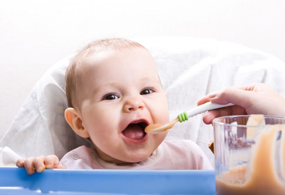 Madre dando de comer a bebé