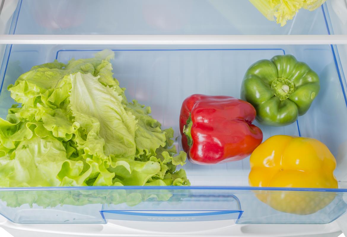 Cajón de la nevera con lechuga y pimientos