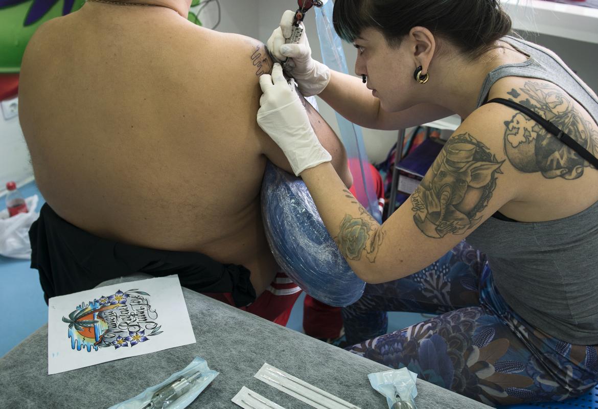 Chica haciendo un tatuaje