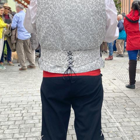 Vecino del barrio de Lavapiés durante la celebración de las Mayas hombre de espaldas vestido con trajes tradicionales