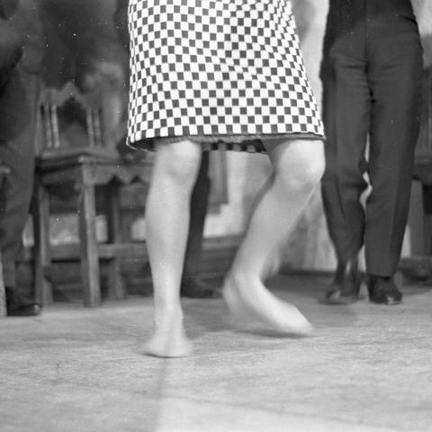 Mujer bailando descalza y hombre bailando, solo se aprecia de la cintura a los pies